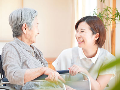 高齢女性と話す介護士