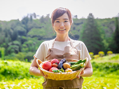 採れたての野菜を持つ女性